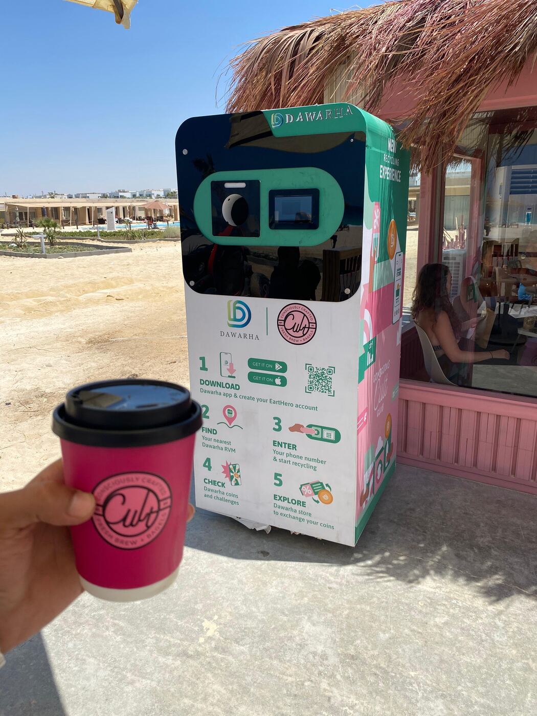 A Cult co-branded Dawarha machine outside a beachfront coffee shop