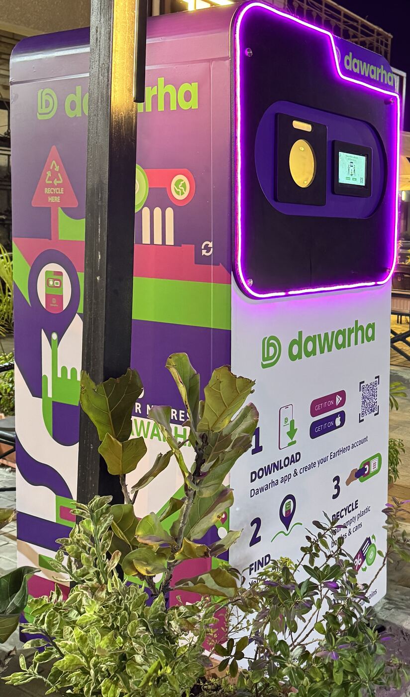 A Dawarha machine with a neon surround in a planted courtyard
